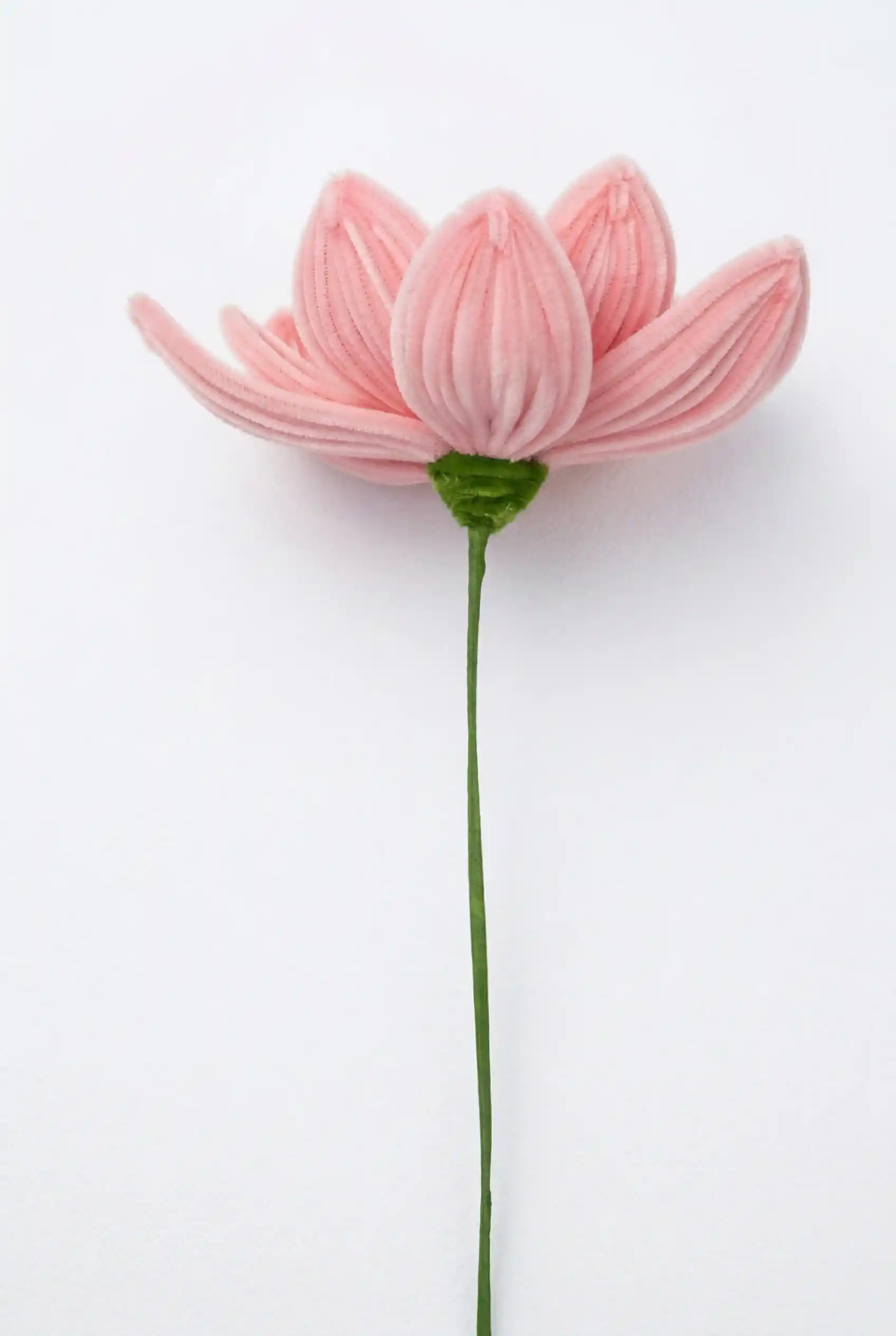 Side view of a finished handmade pink lotus soft sculpture by Glint Garden, showing layered chenille petals.