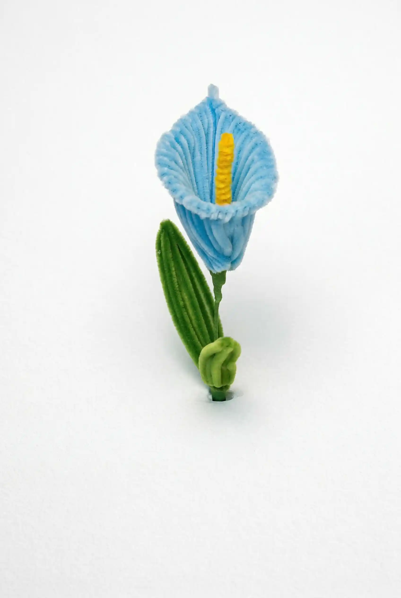 Close-up of a finished handmade blue Calla Lily soft sculpture with a yellow spadix by Glint Garden.