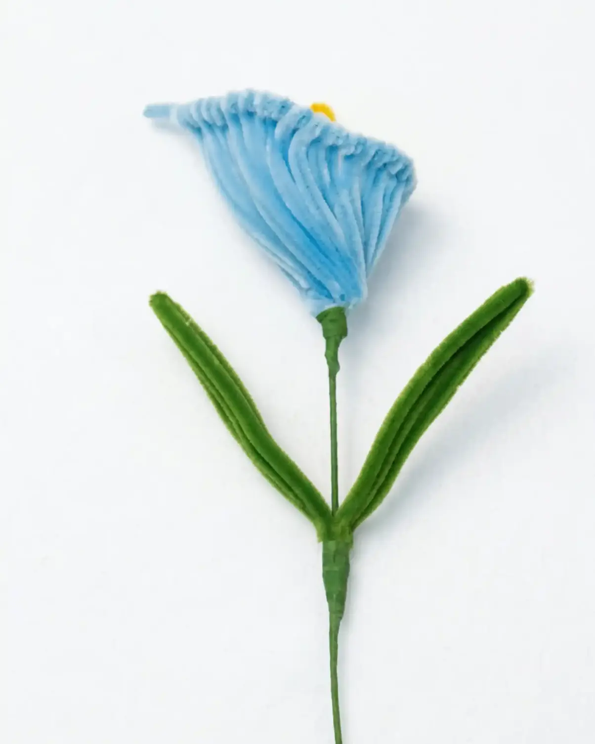 Close-up of a finished handmade blue Calla Lily soft sculpture with a yellow spadix by Glint Garden.