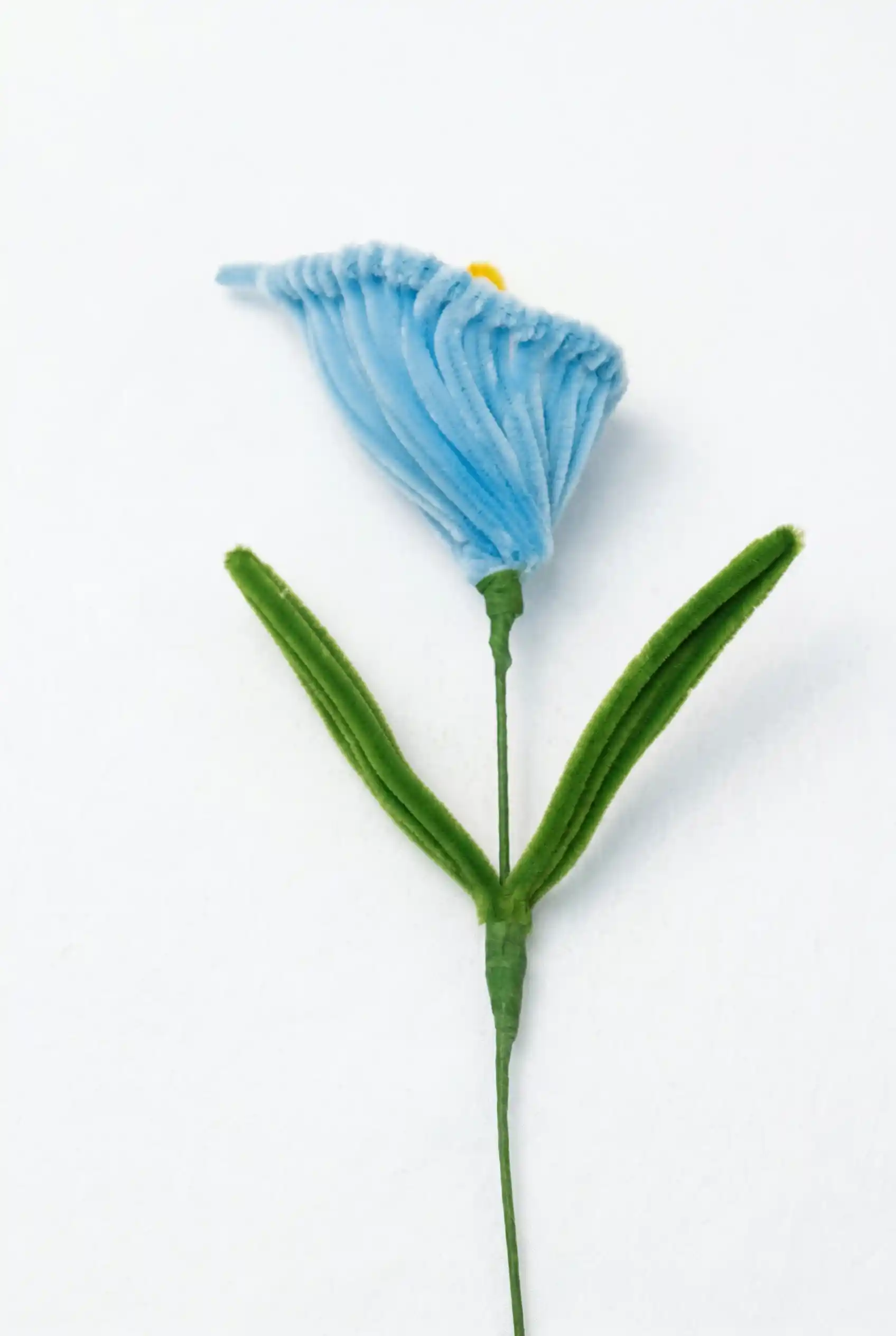 Close-up of a finished handmade blue Calla Lily soft sculpture with a yellow spadix by Glint Garden.