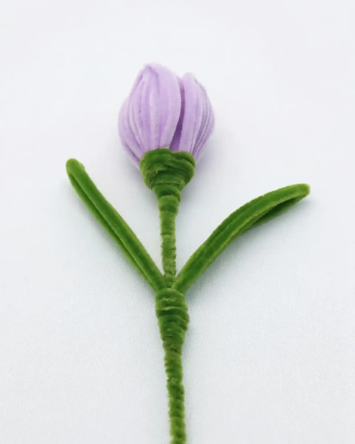 Close-up of a finished handmade lavender tulip soft sculpture by Glint Garden, featuring velvety purple petals.
