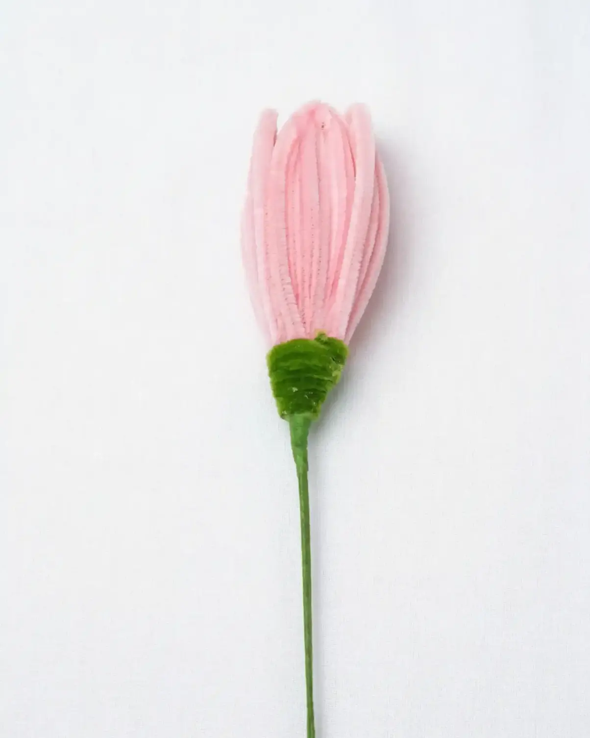 Close-up of a finished pink lotus bud soft sculpture, showing the intricate hand-sculpted velvet petals.