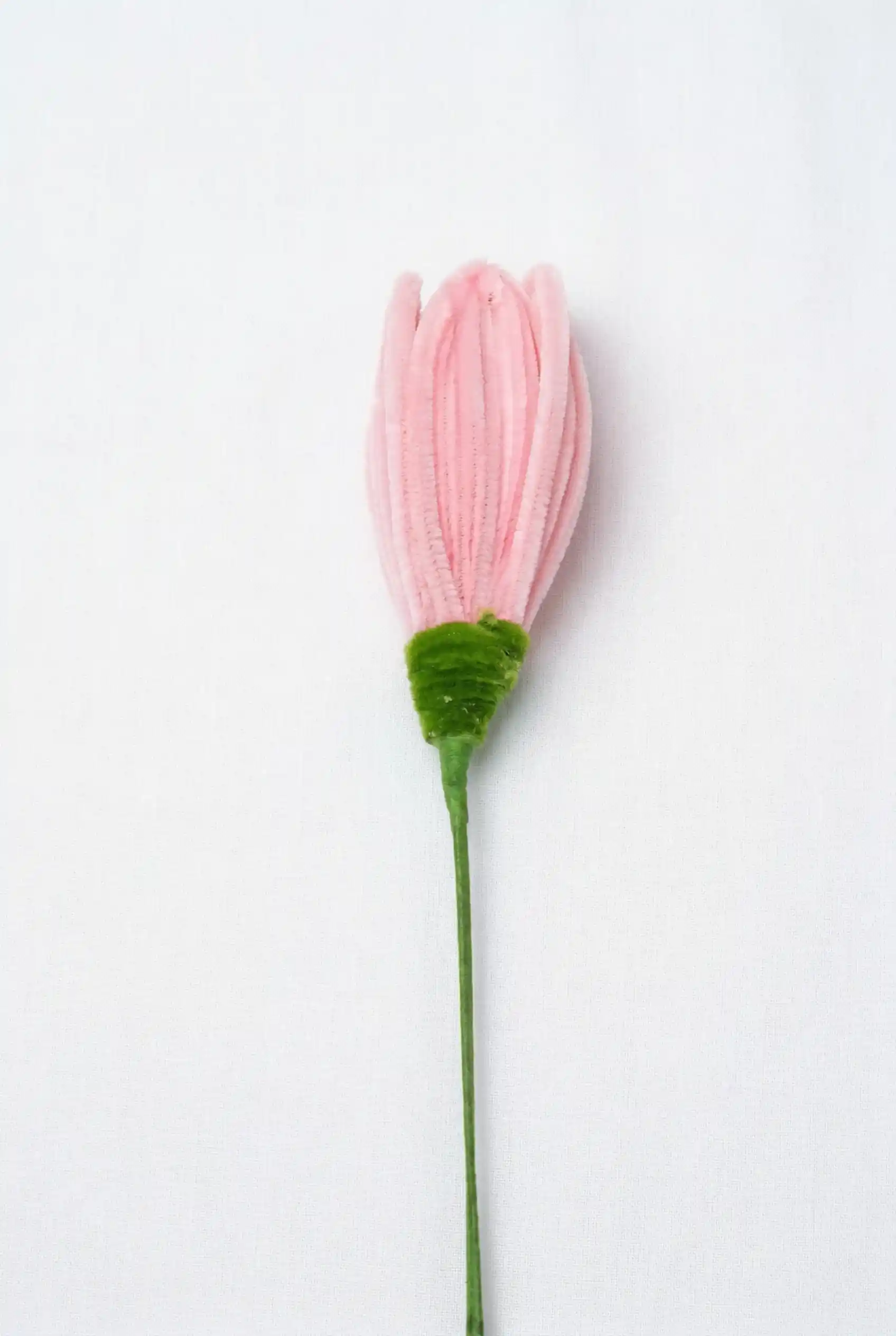 Close-up of a finished pink lotus bud soft sculpture, showing the intricate hand-sculpted velvet petals.