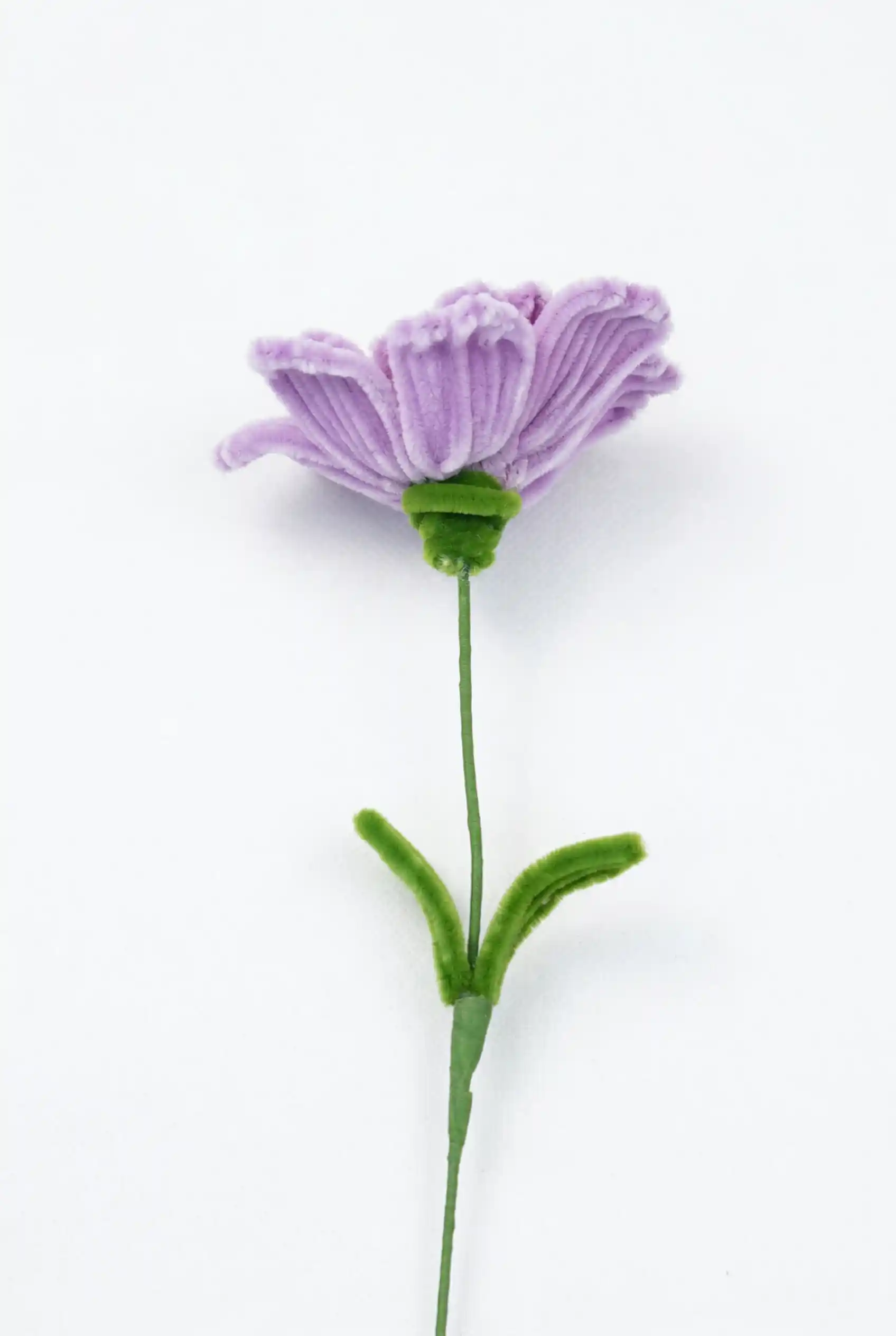 Close-up of a finished handmade lavender Ranunculus soft sculpture by Glint Garden, showing dense, layered velvet petals.