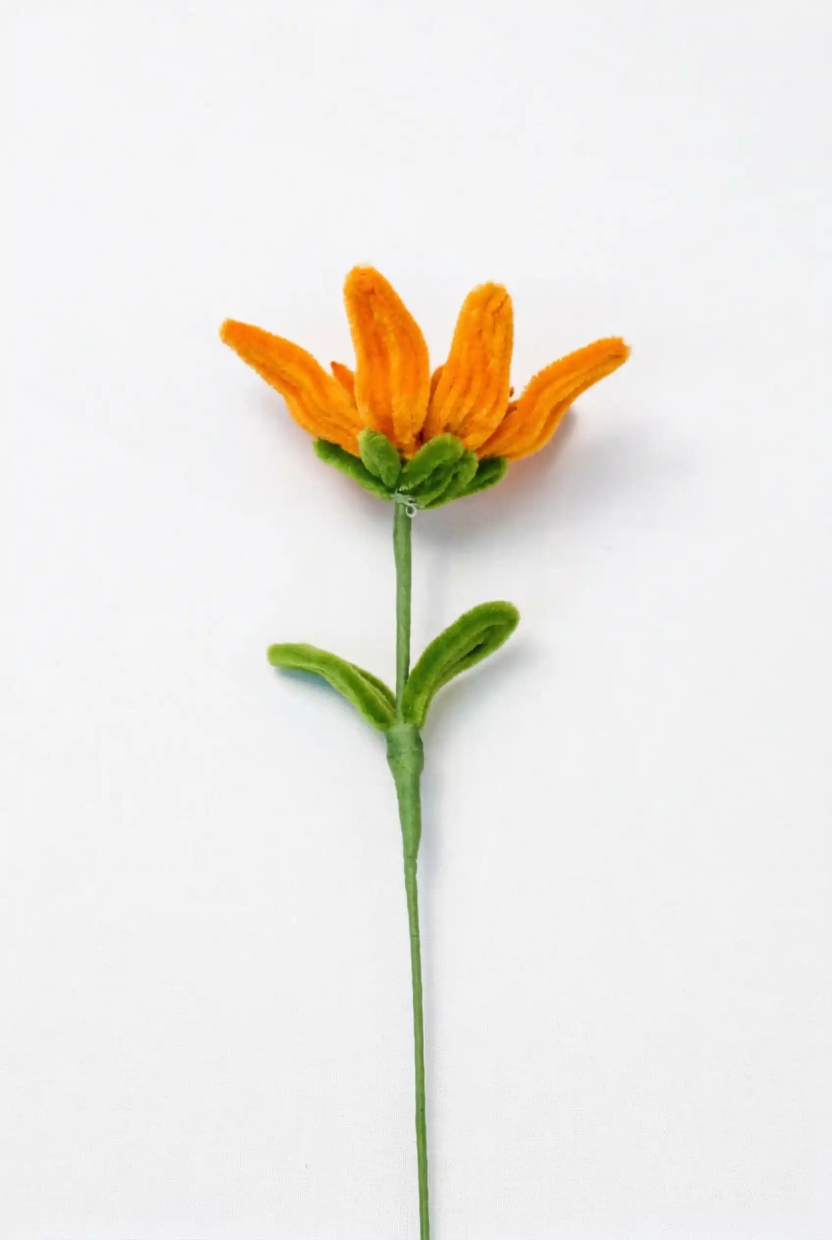 Close up view of a finished handmade Glint Garden oil painting style sunflower soft sculpture with dynamic leaf.