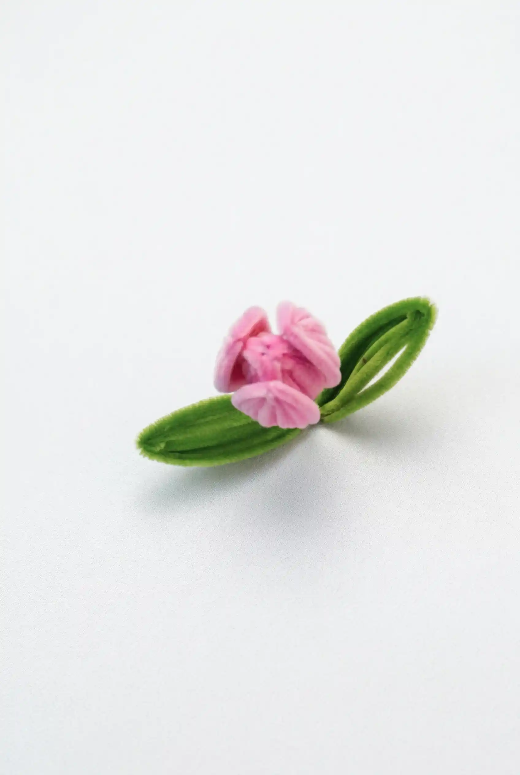 Close-up of a finished pink velvet tulip handmade with premium chenille stems by Glint Garden, showcasing a realistic bud shape.