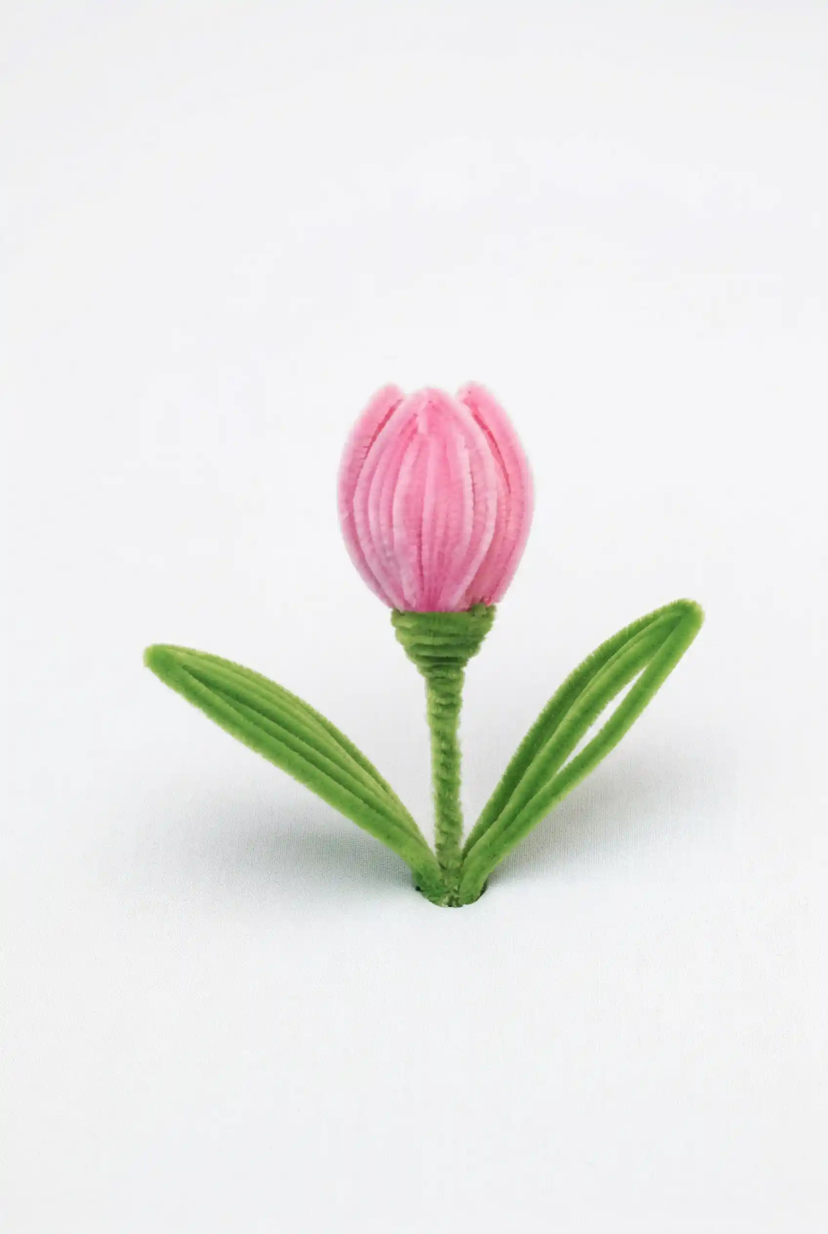Close-up of a finished pink velvet tulip handmade with premium chenille stems by Glint Garden, showcasing a realistic bud shape.