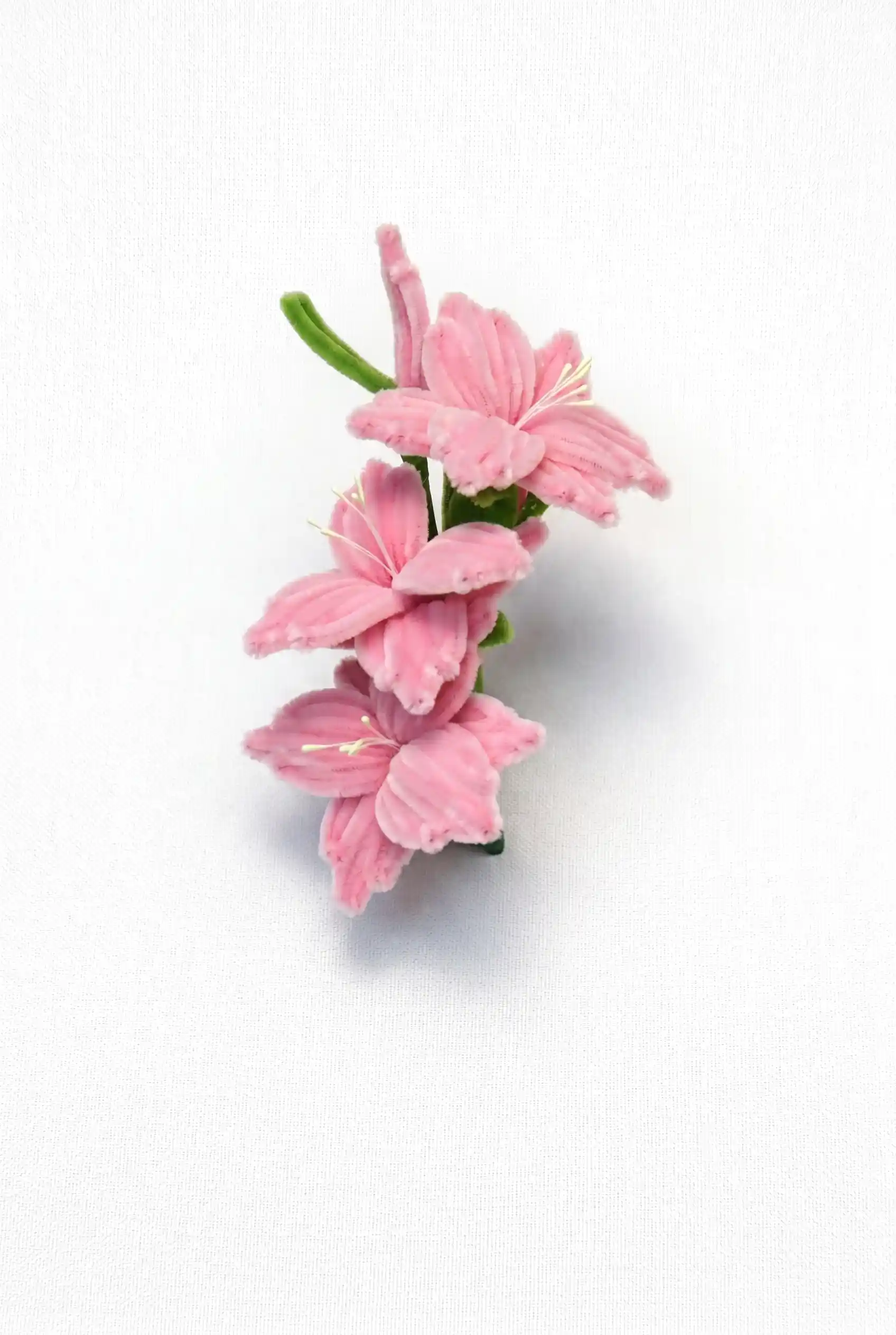 Close-up of a finished handmade pink Gladiolus soft sculpture showing three blooming florets on a stem.