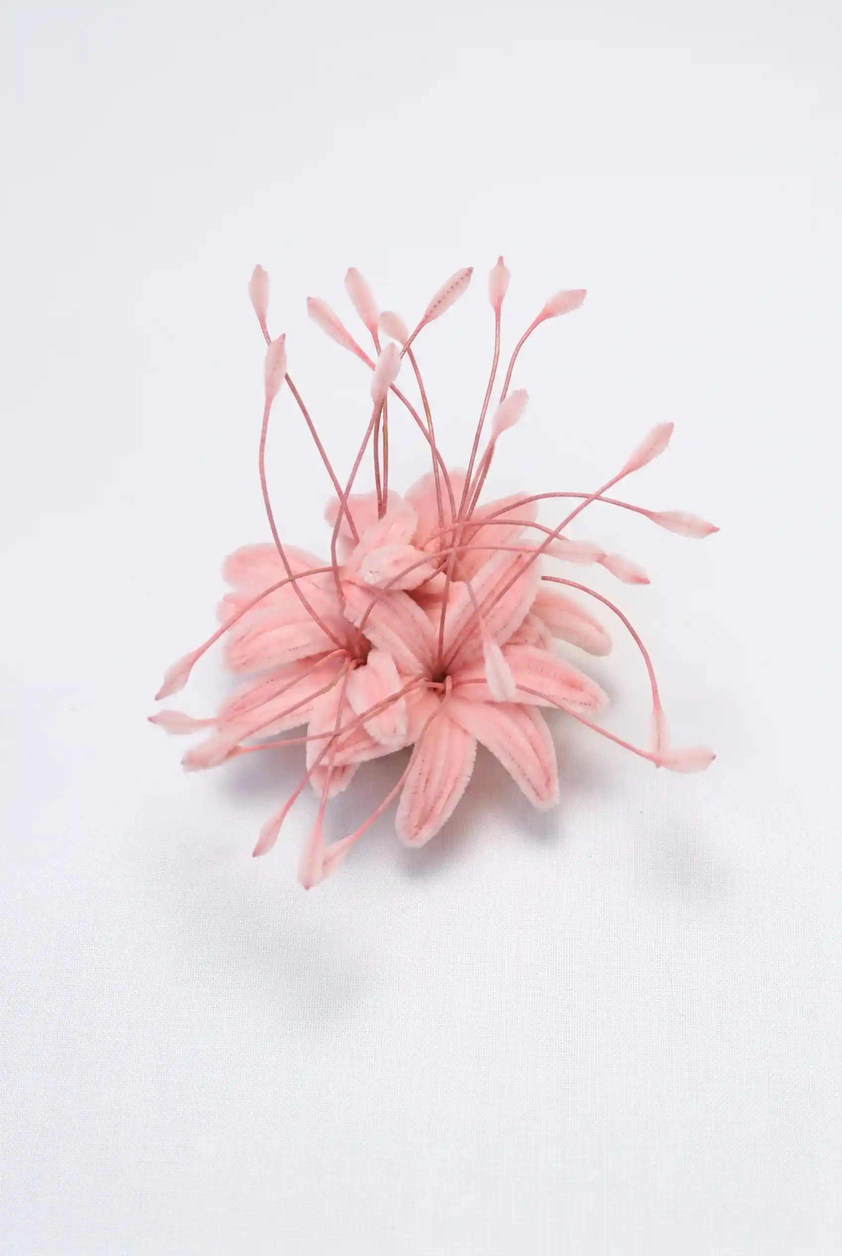 Top-down view of a finished handmade pink spider lily (Lycoris) soft sculpture by Glint Garden, featuring delicate curling petals and long stamens.