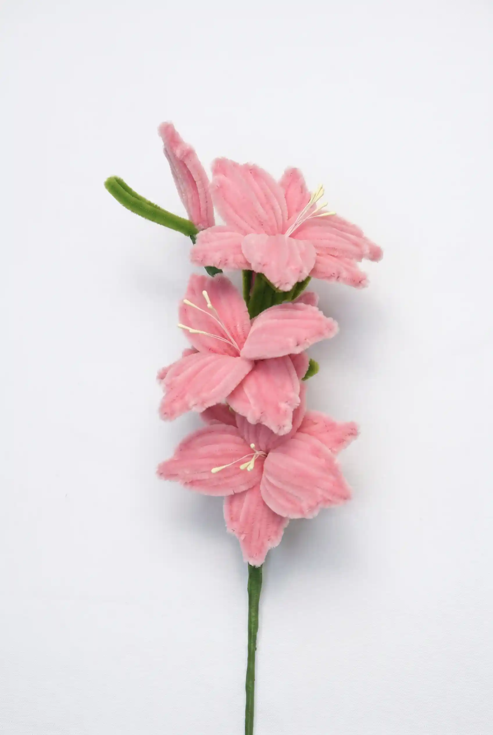 Close-up of a finished handmade pink Gladiolus soft sculpture showing three blooming florets on a stem.