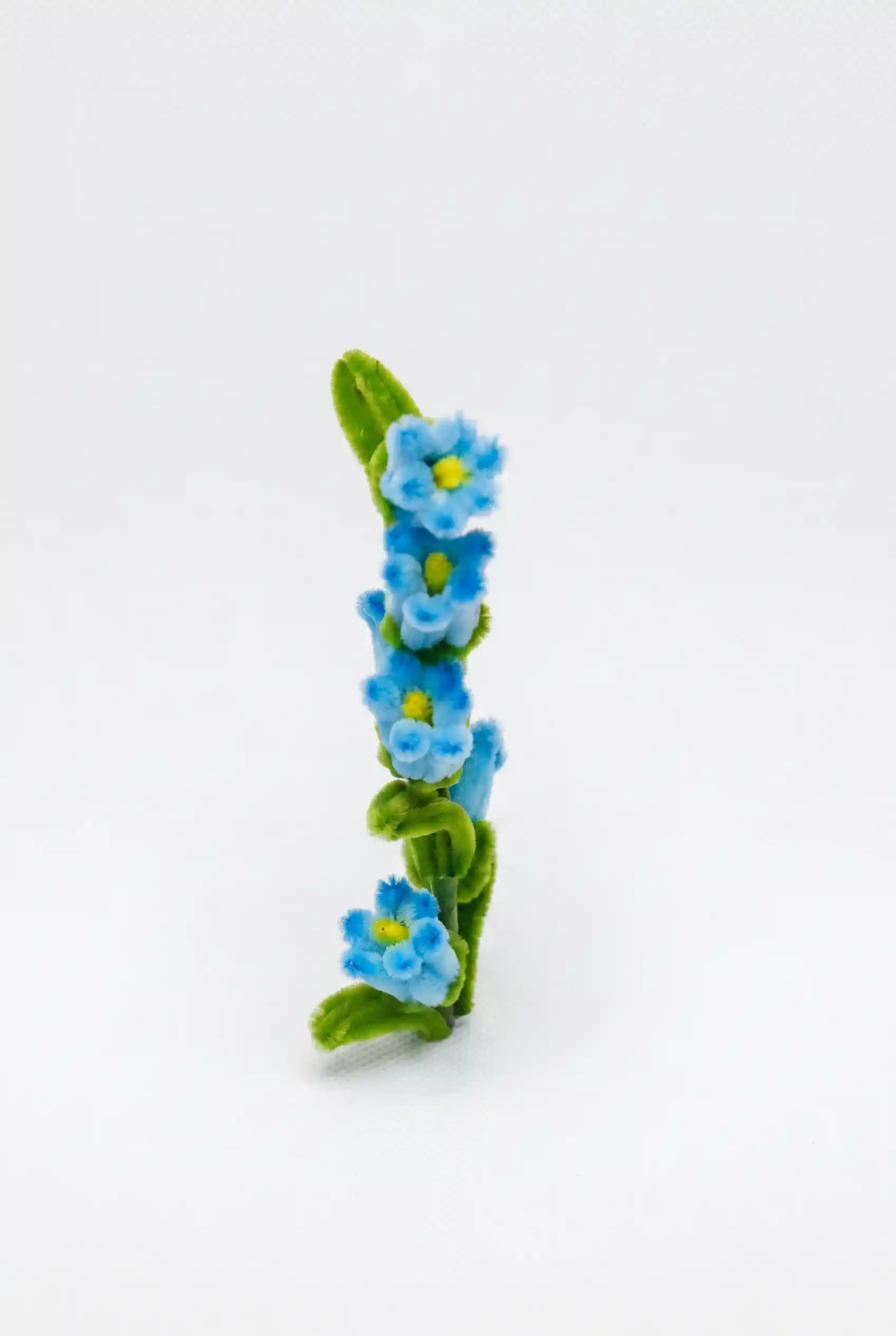 Close-up of a handcrafted chenille bluebell flower cluster showing the delicate bell-shaped structure.