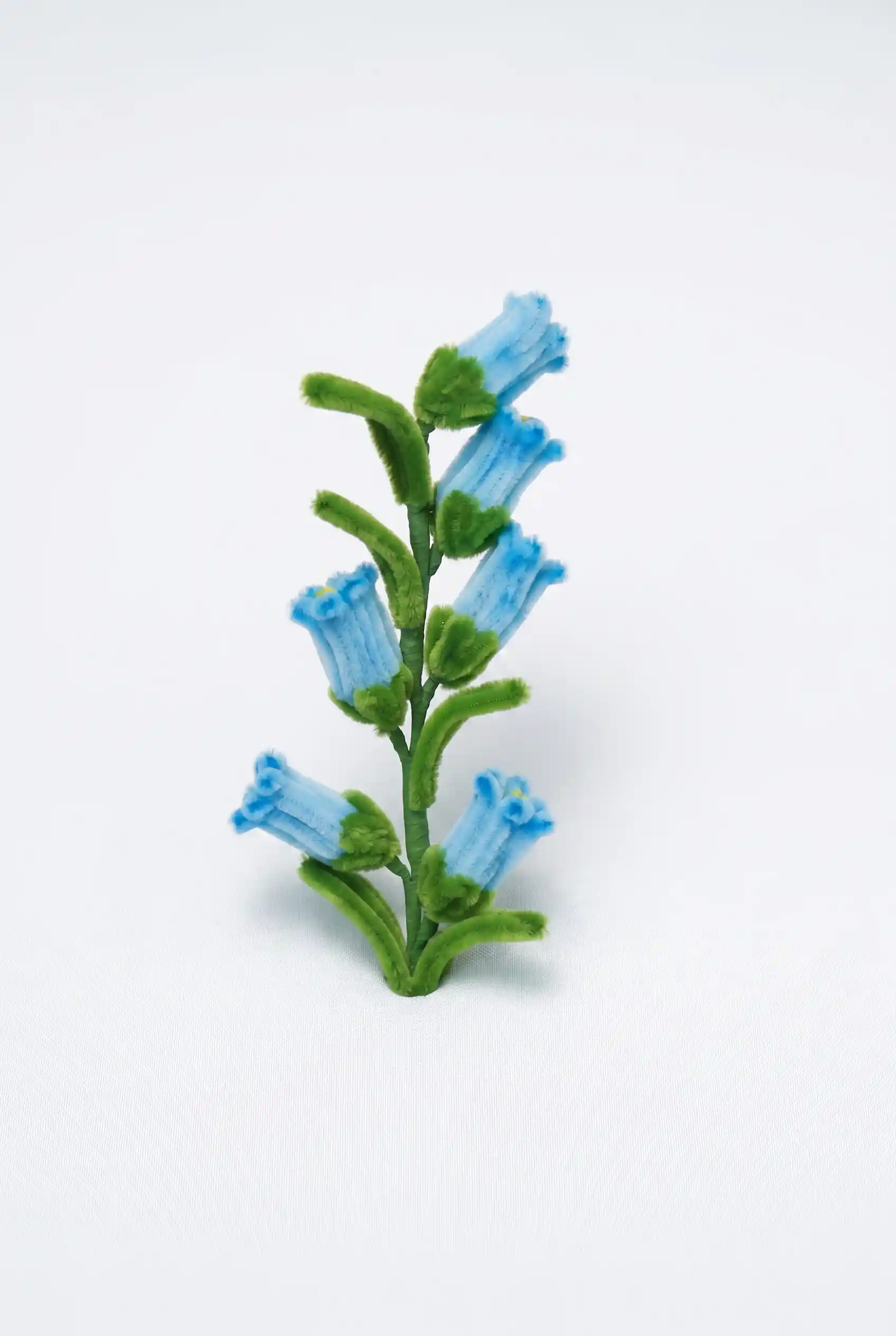 Close-up of a handcrafted chenille bluebell flower cluster showing the delicate bell-shaped structure.